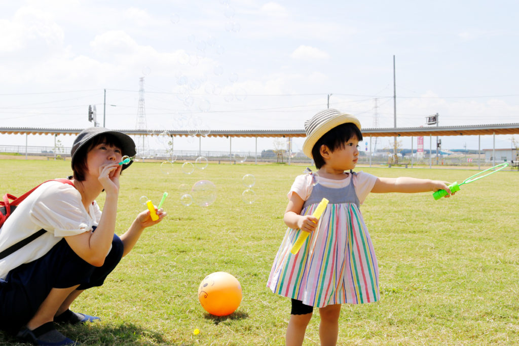 休日に公園で子どもと遊ぶ風景